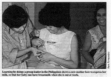 Learning by doing: a group leader in the Philippines shows a new mother bow to express her milk, so that her baby can have breastmilk when she is out at work. 